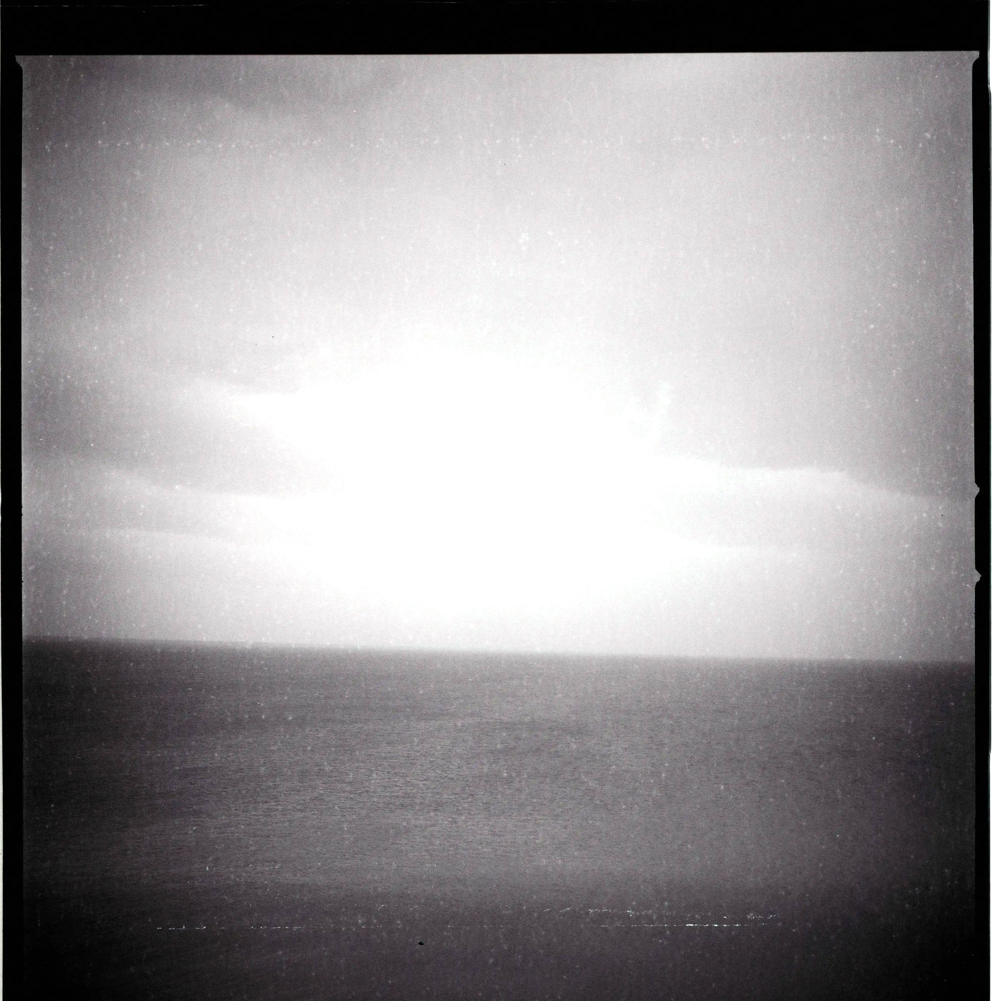 Minimal sea horizon under a bright, overcast sky